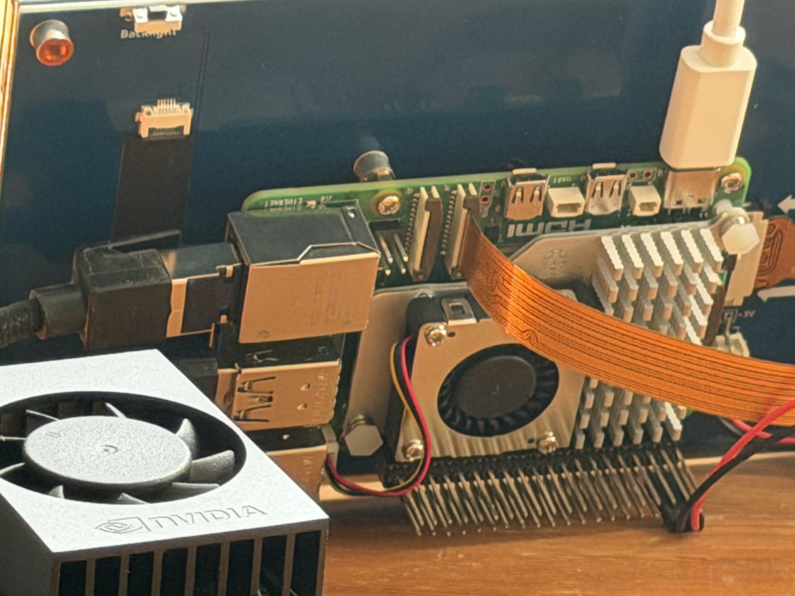 Raspberry Pi 5 and a Jetson module with heatsinks and ribbon cable on a bench